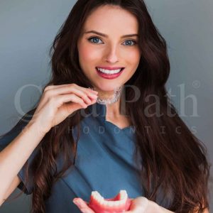 A lady posing with content with her clear aligners.