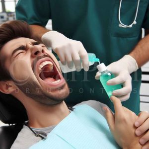 An orthodontist applying a special mouthwash and toothpaste to a patient with severe braces pain