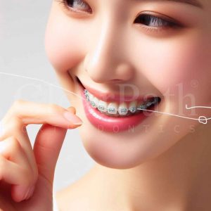 A woman confidently flossing while wearing metal braces 